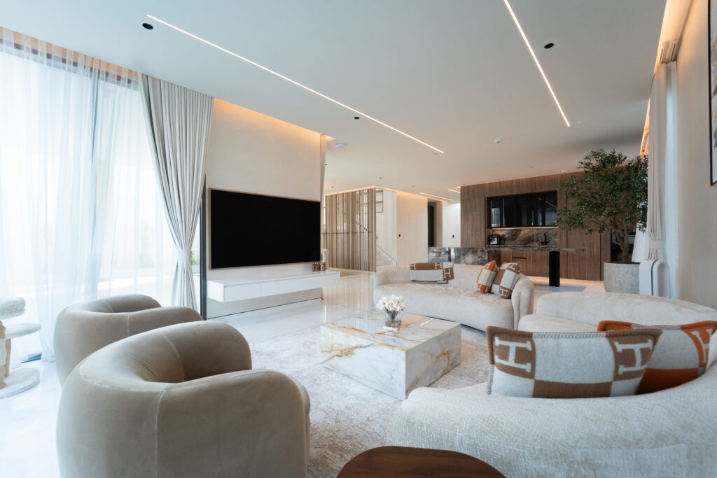 luxury villa interior Dubai - living room with large windows overlooking garden and pool
